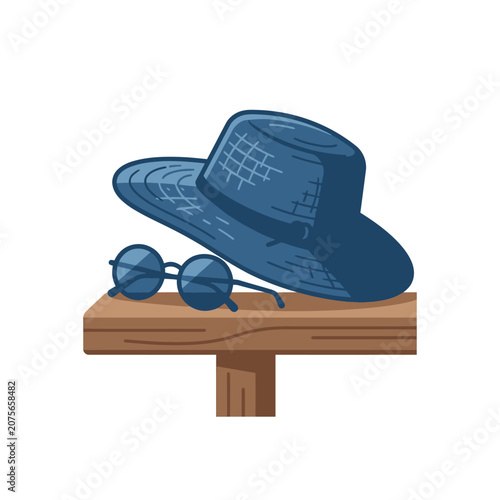 A blue sun hat and round glasses rest on a wooden surface