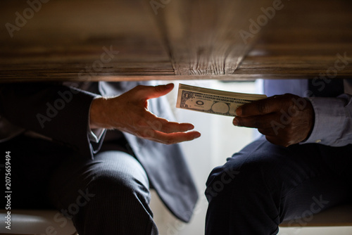 Obraz na płótnie Secretive money exchange under table