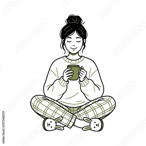 A young woman sits comfortably while holding a warm drink cup