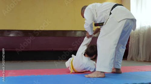 The coach trains the athlete to perform throws and falls