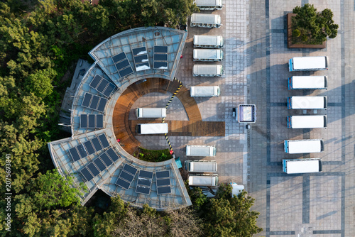 Spiral-shaped photovoltaic roof structure with multiple trucks parked beside it