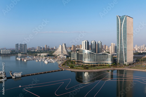 Modern architectural complex and yacht marina along Jinji Lake in Suzhou under clear morning sky