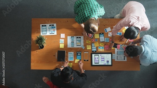 Obraz na plátně Top down view of business team writing idea on sticky note while planing for Ux Ui design for mobile phone interface