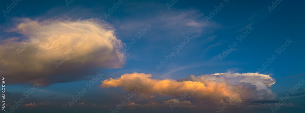 Obraz premium Dramatic sunset sky covered with colorful yellow clouds. Panoramic skyscape