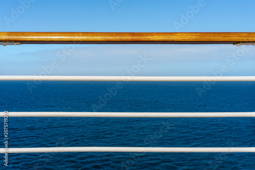 Cruise ship deck railing and a ocean view with blue sky
