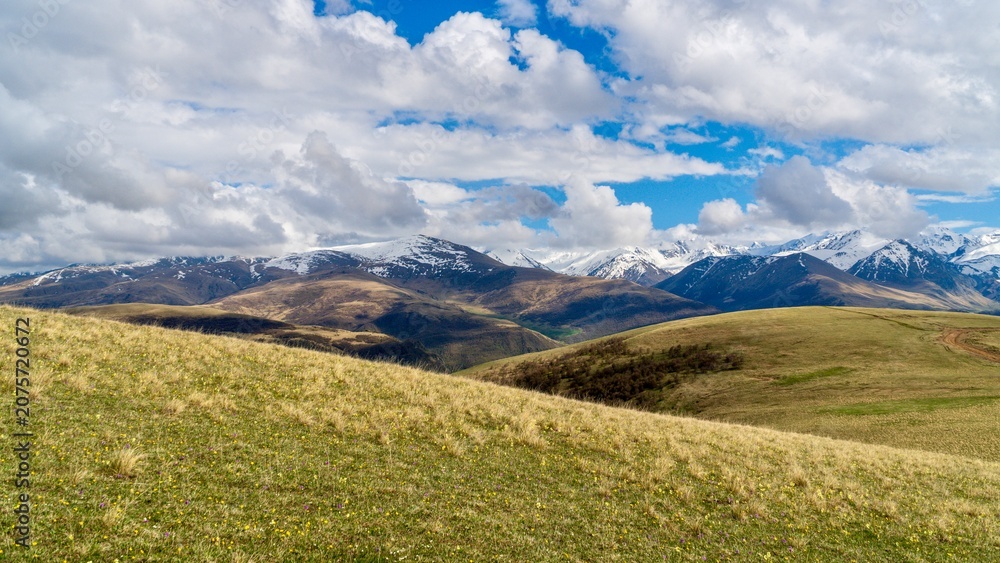 Fototapeta premium Dzhily-Su, Russia - June 4, 2026: View of the Caucasus Mountains along the road to Dzhily-Su, showing mountain peaks, valleys, winding road, open landscapes, and scenic natural surroundings.
