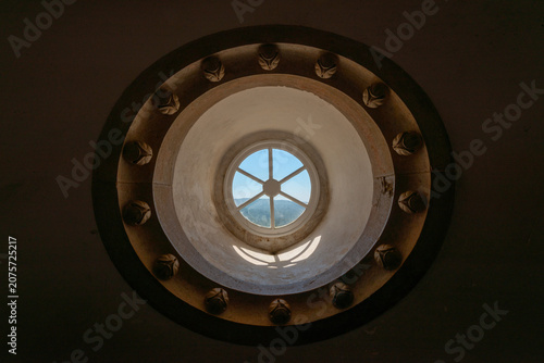 Canvas Print Circular stone tower window casting light inside historic fortress interior