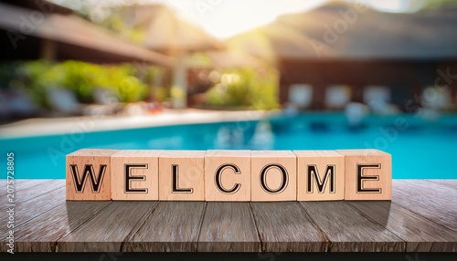the word welcome made of wooden letters on the table by the poolside summer background with a blurred swimming pool and sunlight effect
