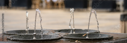 Fotografie Public drinking water fountain providing clean potable water, symbolizing accessibility, hydration, urban infrastructure, and public health in a city environment
