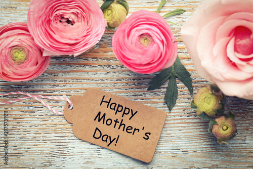 Happy Mother's Day tag and beautiful flowers on wooden background, flat lay