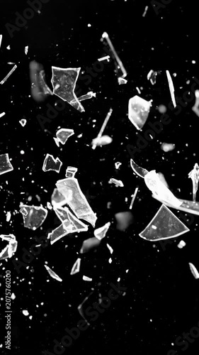 Vertical Glass Shards Flying out of Darkness 4K Loop features glass shards flying toward the viewer out of a black background in a loop.