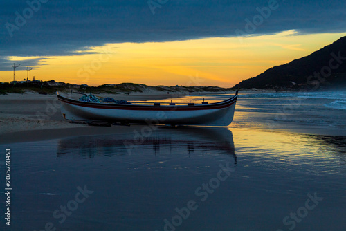paisagem do pôr-do-sol na praia do Santinho, Ingleses, Florianópolis, Santa Catarina, Brasil e o barco de pescada tainha