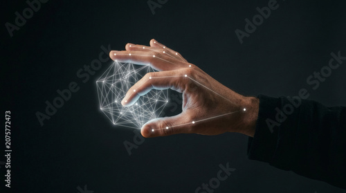 A side view of a human hand reaching out, with elegant, glowing white tracking dots and thin vector lines mapped precisely onto the fingers, manipulating an invisible object. Neutral dark studio 