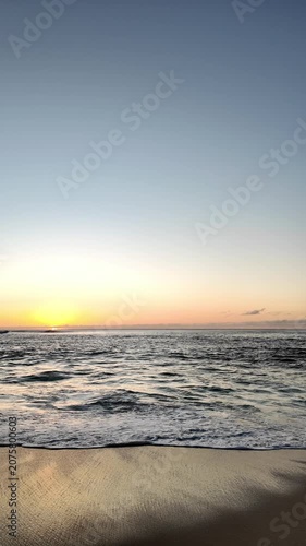 People watching  a golden sunset over the hawaiian coastline
