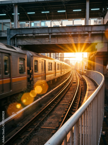Commuter train on urban railway at sunset.