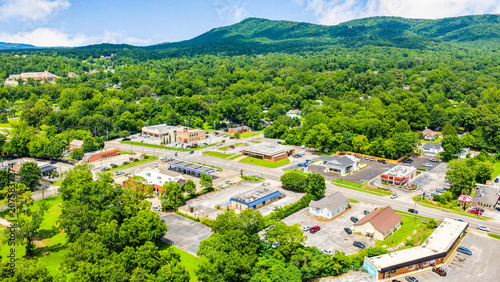 Aerial view of a small town nestled in a lush green valley with mountains in the background