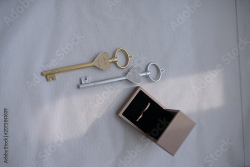 Elegant gold and silver heart-shaped keys displayed with a minimalist ring box for romantic wedding or engagement concepts