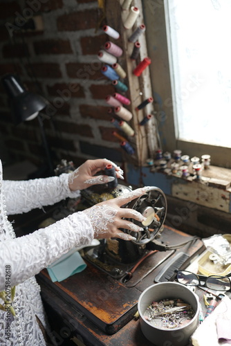 A skilled artisan meticulously works on a vintage sewing machine, surrounded by spools of colorful thread and crafting tools, highlighting traditional textile craftsmanship