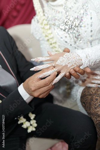 Groom placing a wedding ring on his bride during a traditional ceremony representing commitment and eternal love