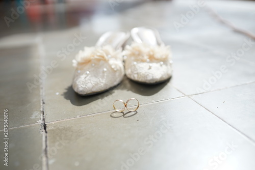 Elegant Wedding Accessories Featuring A Pair Of Golden Rings And Delicate Bridal Shoes For A Romantic Celebration