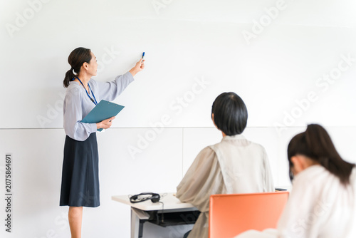 Foto Female instructors, teachers, and cram school instructors who give lectures in front of a whiteboard at cram schools, seminars, and workshops