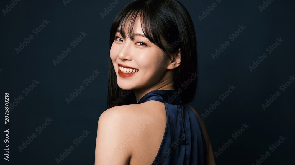 Fototapeta premium Elegant Portrait of a Smiling Young Woman with Dark Hair in a Sophisticated Blue Evening Dress