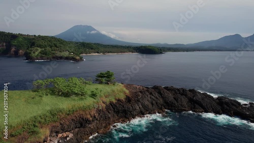Aerial View of Rocky Island, Ocean Coastline, Sailboats and Distant Volcanoes in Bali