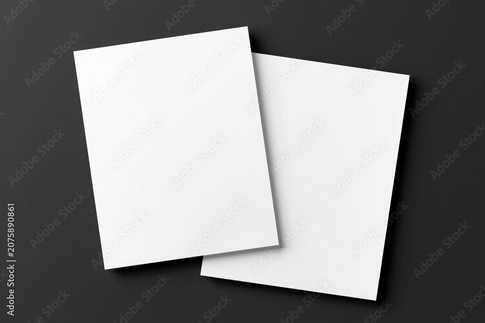 Fototapeta premium Blank papers lie flat on dark surface