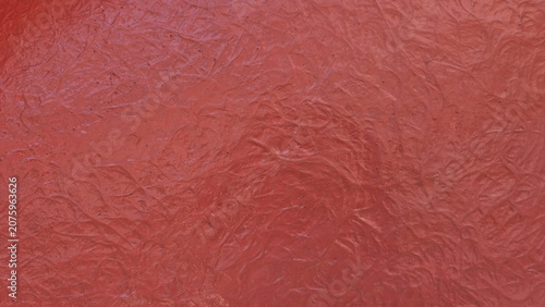 Fotografie A close-up shot showing a textured, solid red surface with a chaotic, swirly, or fibrous pattern molded into it
