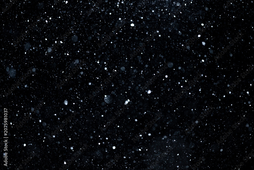Fototapeta premium Snow overlay layer on dark background. Snow particles drifting in winter storm. Snow texture with falling snowflakes. Snowfall effect with cold motion.