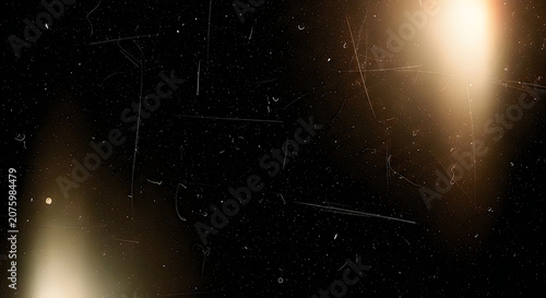 Abstract dark film overlay texture featuring subtle golden light leaks and vintage dust scratches on a deep black background surface