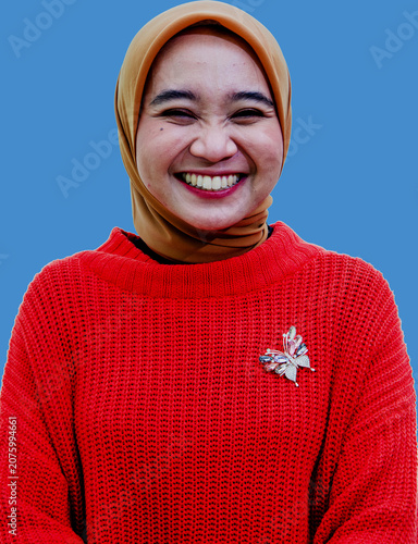 Foto Woman in a red sweater smiles and reacts with surprise