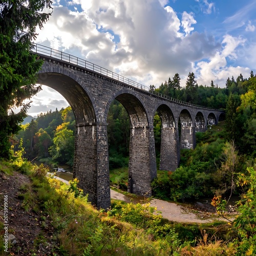 A serene landscape featuring a long, arched stone bridge surrounded by lush greenery and a cloudy sky