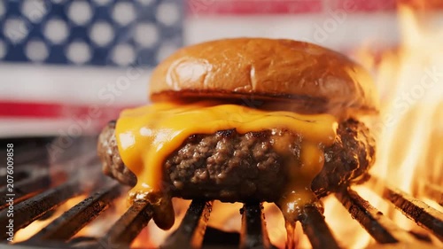 Juicy cheeseburger grilling over open flames with American flag