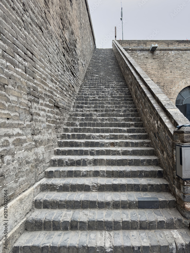 Obraz premium Stone stairs between brick ramparts at city wall access in Xian China during day