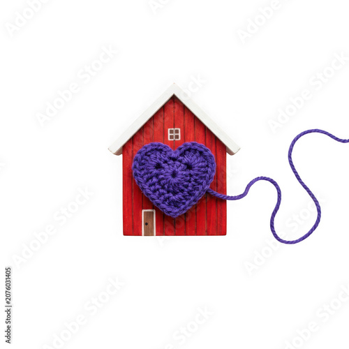 Red house with purple crochet heart and yarn.
