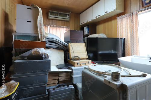 遺品整理で家具や家財道具が積み重ねられた室内の様子