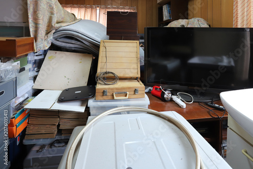 遺品整理で家具や家財道具が積み重ねられた室内の様子