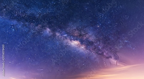 The milky way galaxy at dusk with a starry night sky and purple clouds