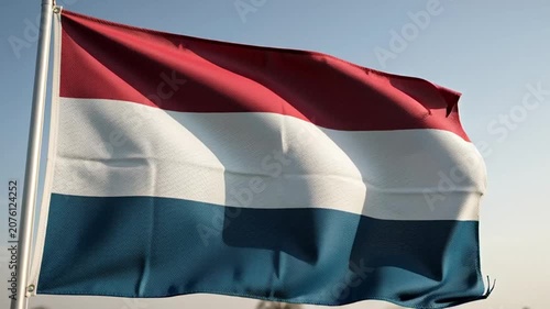 Dutch Flag Waving in the Wind Against a Clear Blue Sky.