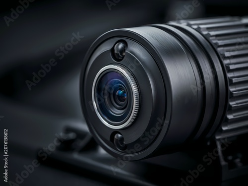 Closeup of a black camera lens with silver accents and ribbed body