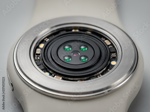 Closeup of smartwatch camera lens with silver bezel and white strap