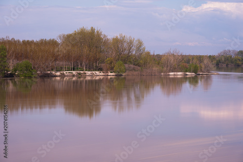 nature sceneries along the Po river embankments in Castelmassa area with a cloudy sky in the backgrounds, Rovigo, Italy
