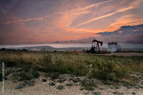 Foto An old oil pumpjack silhouette at sunset in Ayoluengo fields Burgos Spain repres