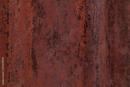 Rusted corrugated metal sheet texture with peeling red paint