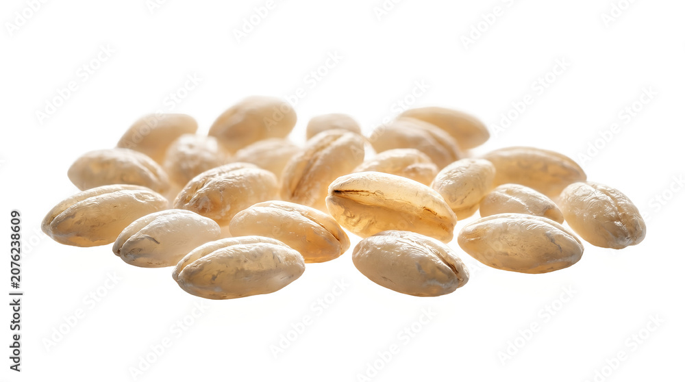 Obraz premium Barley grains are gathered in a small pile on a white surface to highlight the natural shape of the cereal.