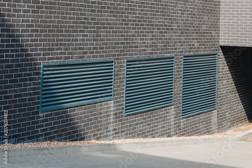 Teal Ventilation Grilles on Gray Brick Building Facade
