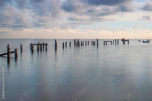  Swanage Dorset Serene Wooden Pier Ruins Over Calm Sea With Boats and Cloudy Horizon At Sunrise