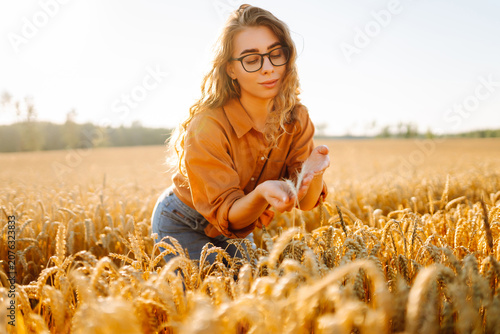 Cuadro en lienzo Female agronomist works in field, holding golden ears of grain