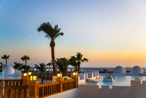 A magical sunrise over the sea with Egyptian resort hotels lining the coast. A vibrant, romantic resort landscape.